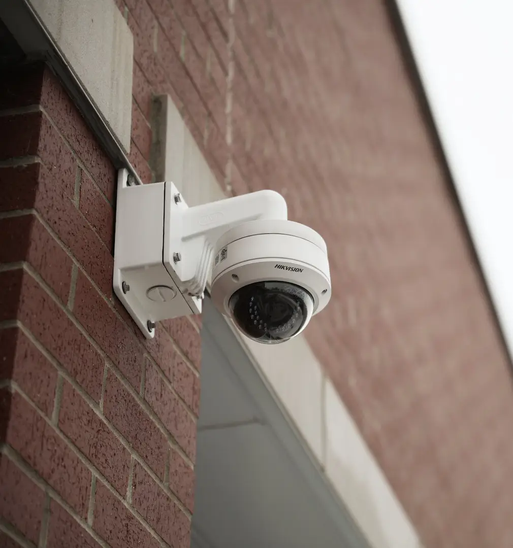 Exterior security camera mounted on brick wall