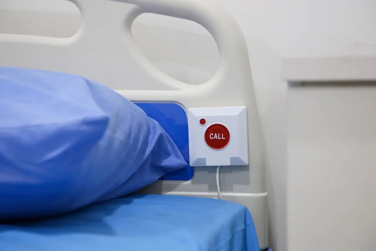 Hospital bed with integrated nurse call system